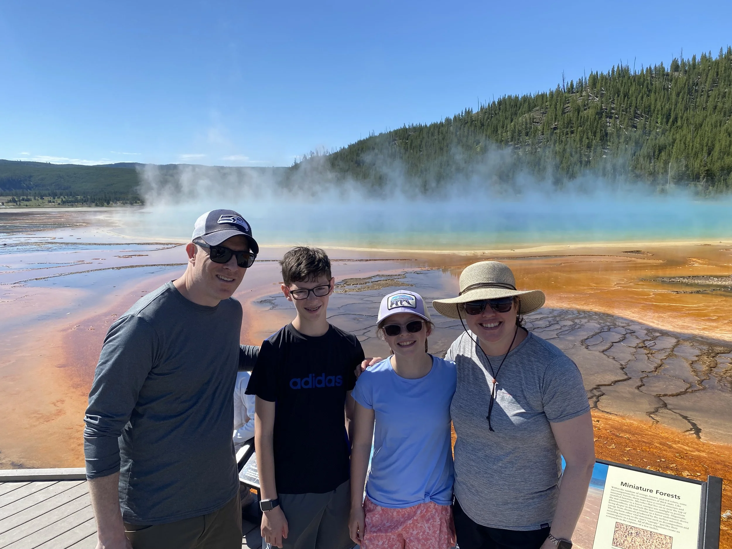 Family in front of Grand Prismatic at Yellowstone National Park