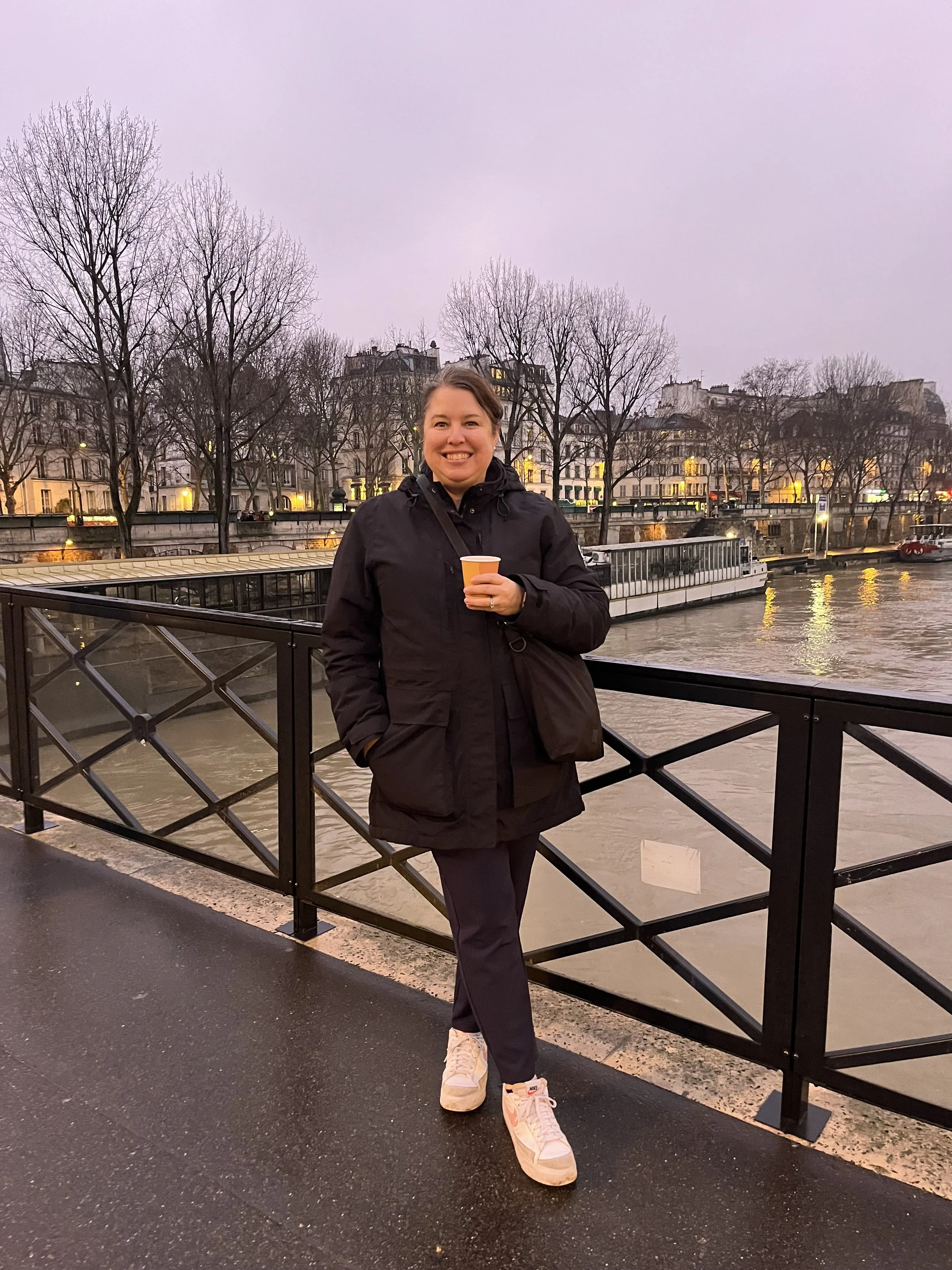 Woman on a bridge in Paris drinking wine