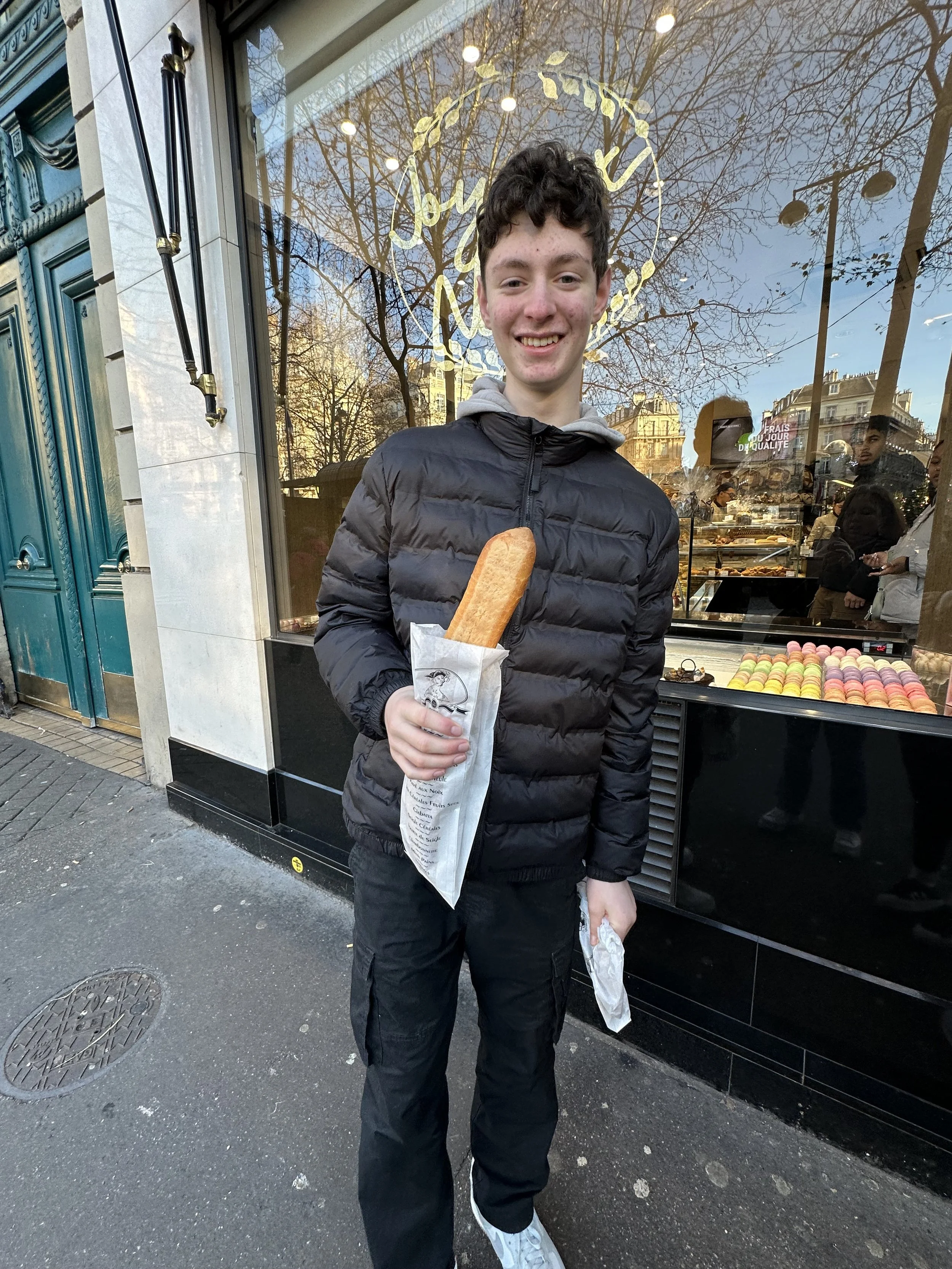 American Teenage boy with a baguette & croissant in Paris, France