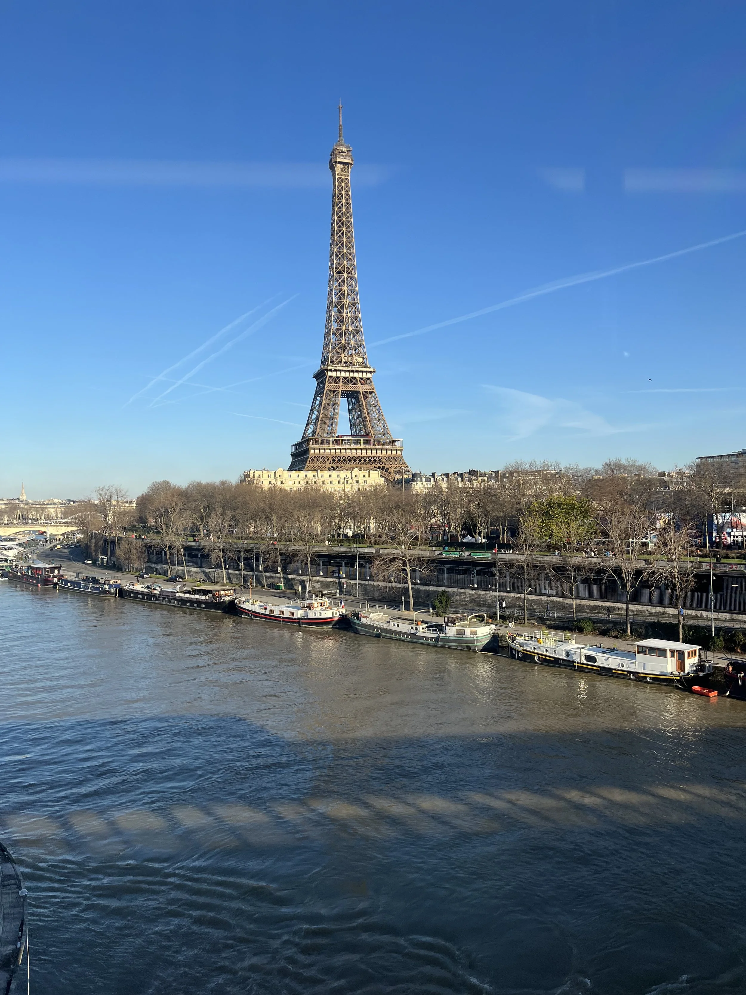 View of the Eiffel Tower from a train in Paris France on a beautiful, sunny day.