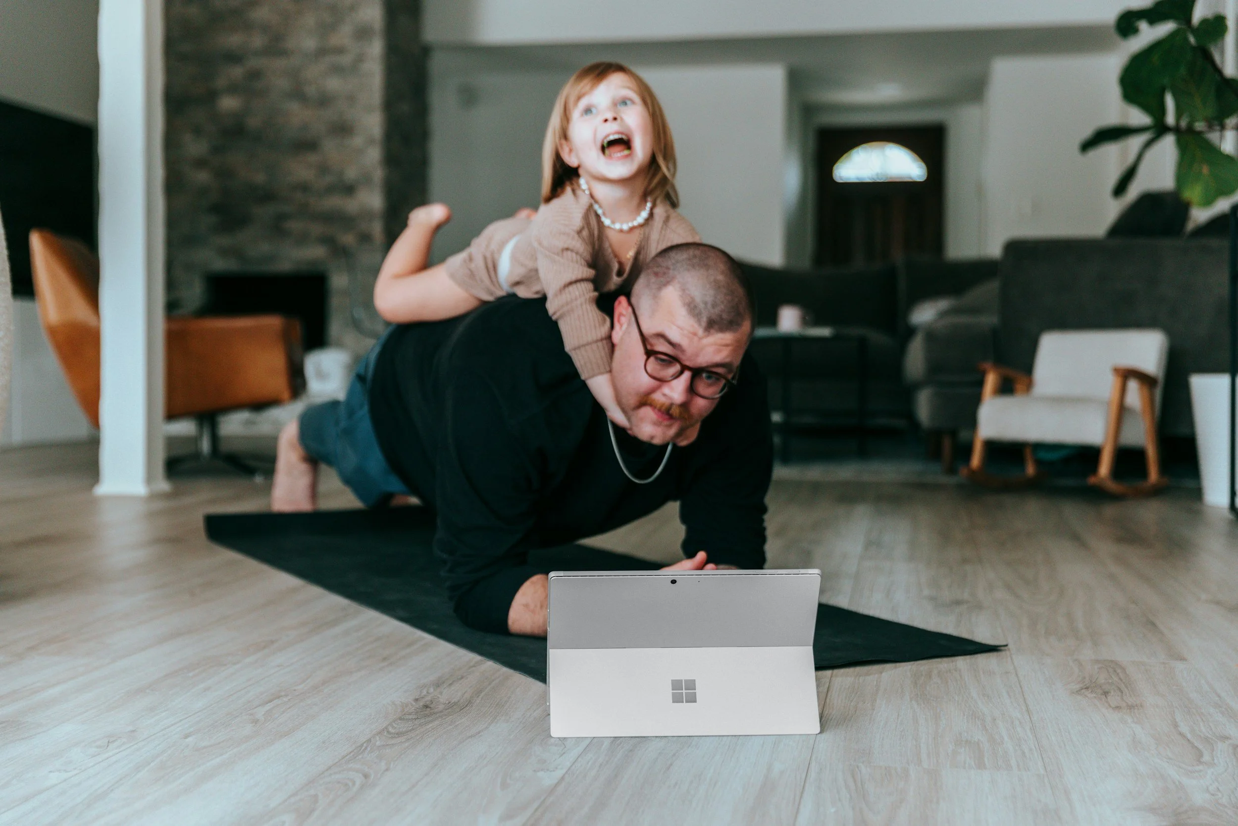 A laptop on a wooden surface displaying a virtual personal training session with two people visible on the screen, and the text "Virtual Personal Training" above it.