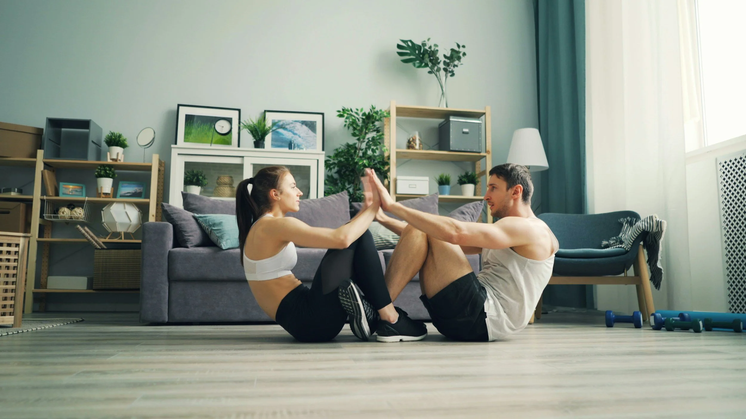 Couple participating in a personalized fitness training session together from home as part of a Body Soul Training wellness and lifestyle program in Providence, Rhode Island.