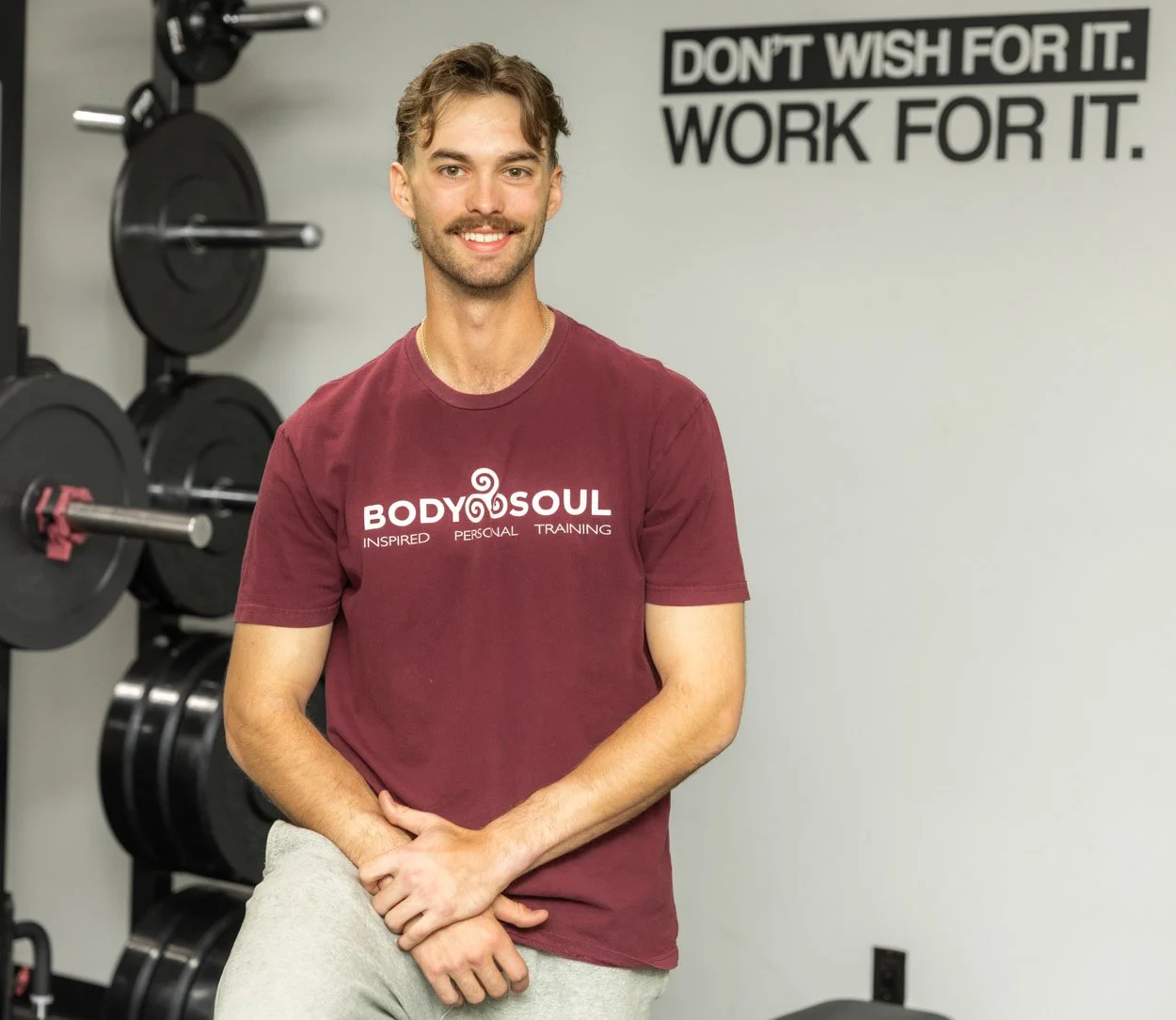 Trainer at Body Soul Training standing in workout space highlighting the connection between strength training and mental wellness