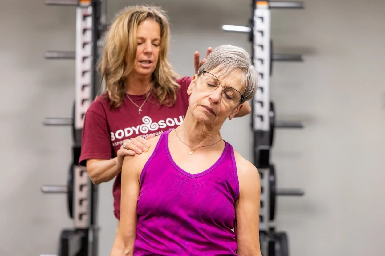 Personal trainer assisting a client with guided neck and shoulder stretching during a mobility training session at Body Soul Training in Providence, Rhode Island.