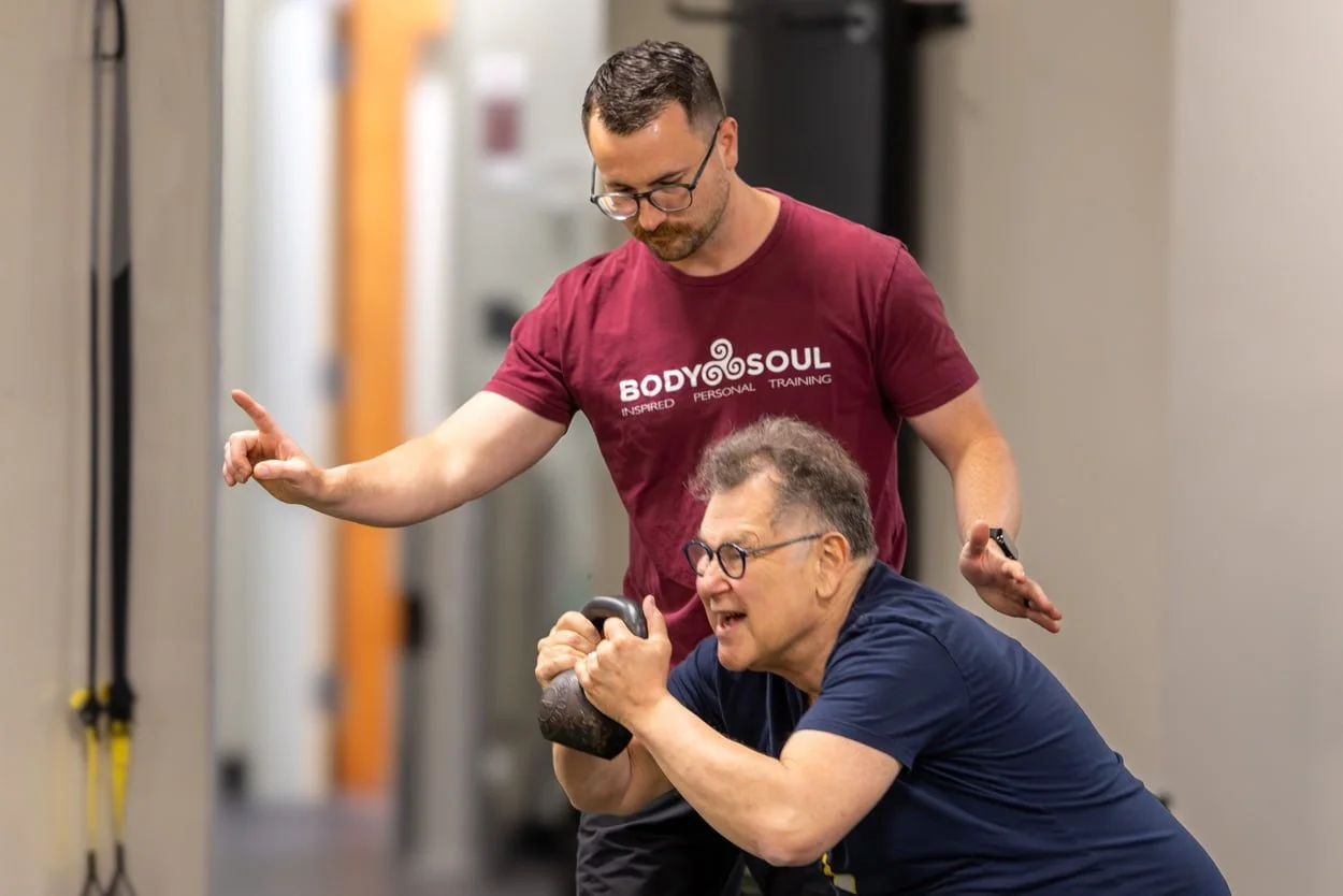 Personal trainer guiding a client through a kettlebell exercise at Body Soul Training in Providence, Rhode Island.