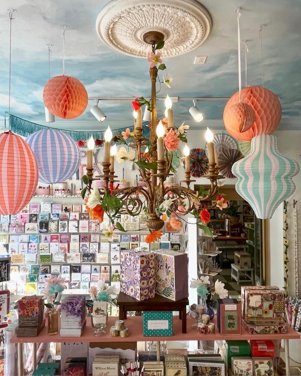 Chandelier inside of a party store with decorations around it.