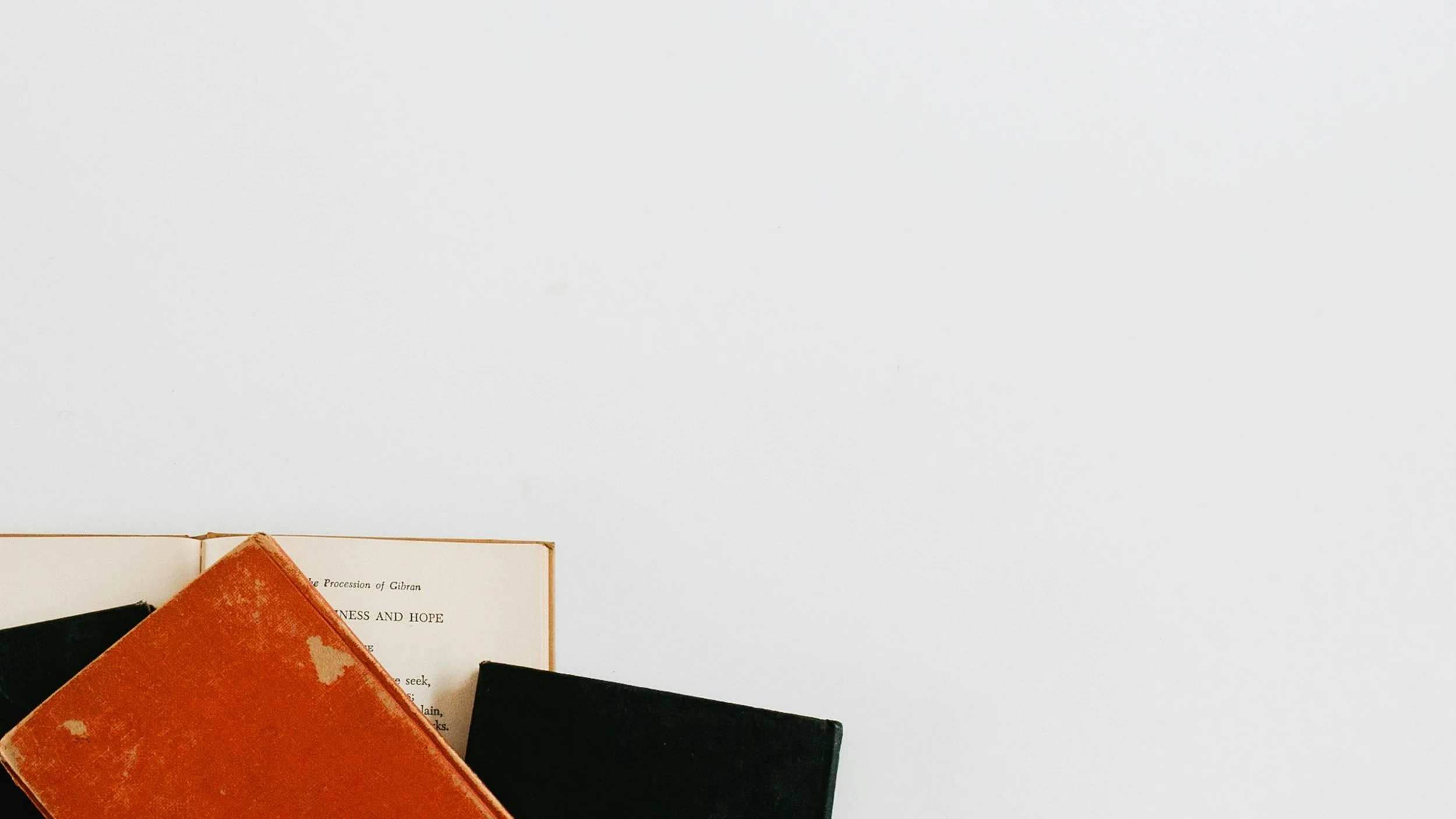 Red and black book stacked on top of an open book.