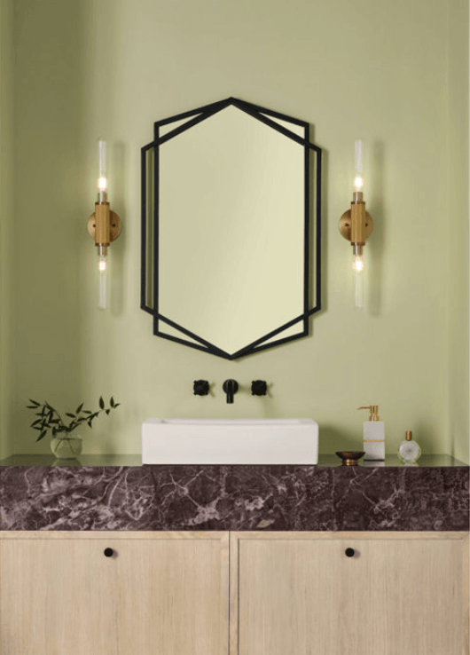 Modern bathroom featuring Sherwin-Williams Celery SW 6421, the 2027 Colour of the Year, with soft green walls, burgundy marble, and brass sconces.