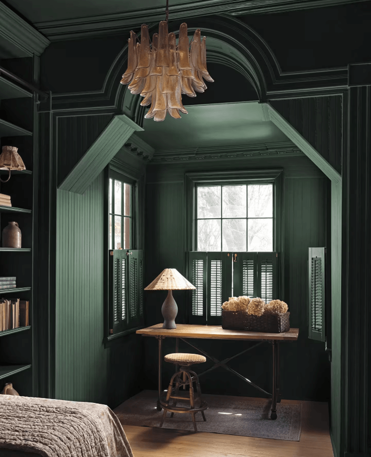 Moody home office painted in Benjamin Moore Webster Green HC-130, the 2027 Colour of the Year, featuring rich green woodwork and vintage furnishings.