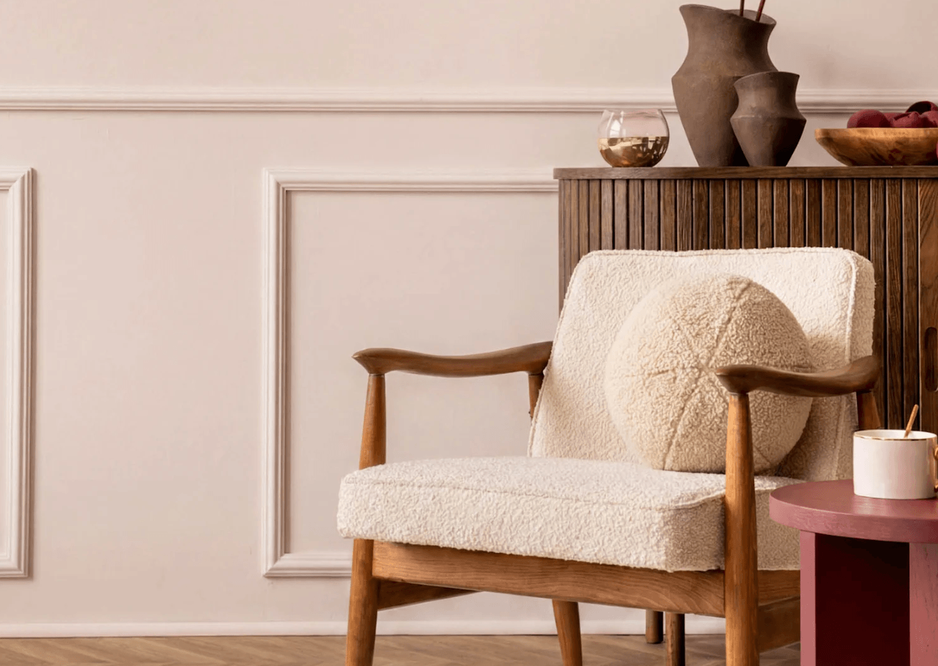 BeautiTone Rosewater TR27-2-1, the 2027 Colour of the Year, featured on soft pink walls with decorative moulding, a boucle armchair, and warm wood accents.