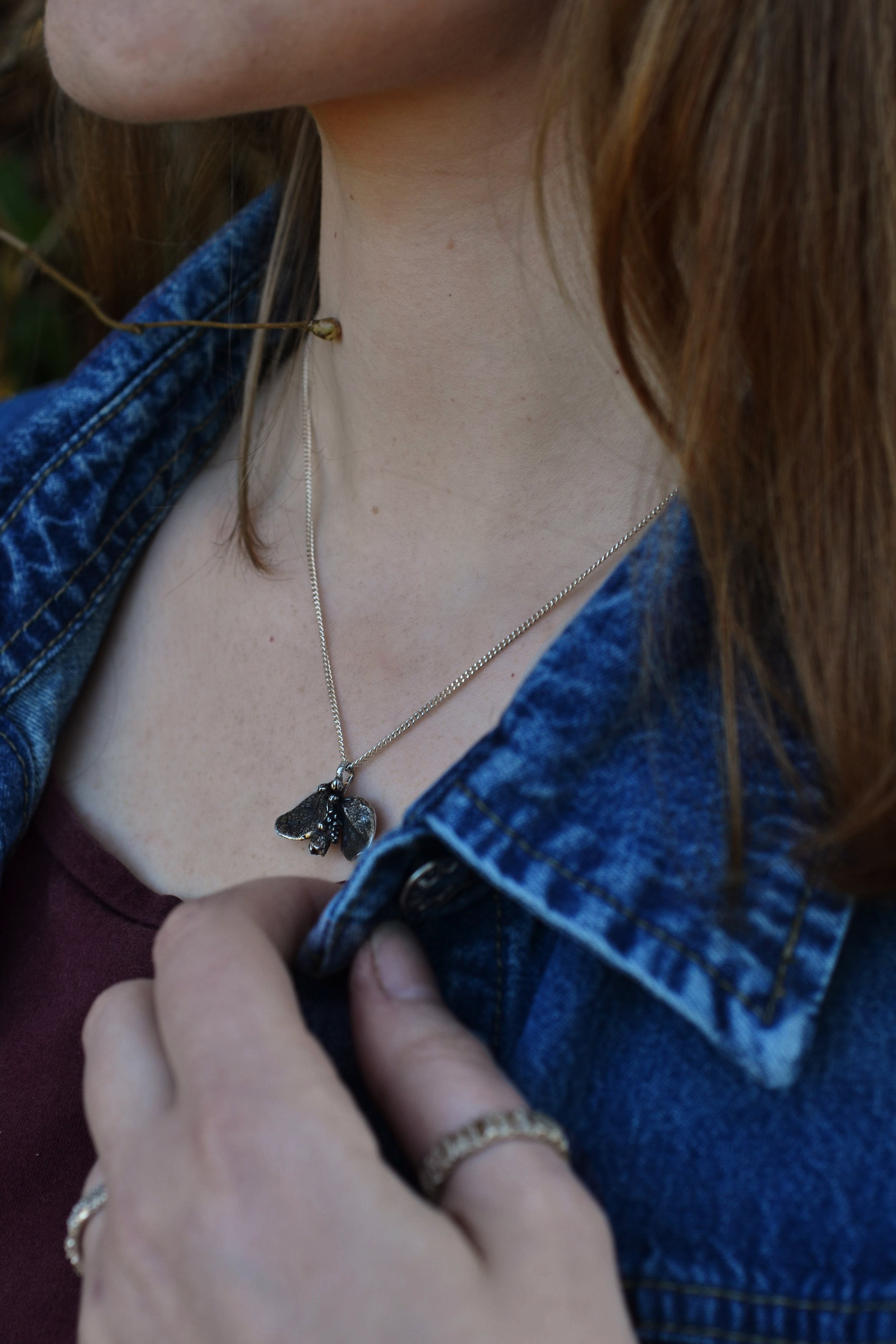 une femme portant une collier avec pendentif feuille en argent massif, par Bijoux de La Lande