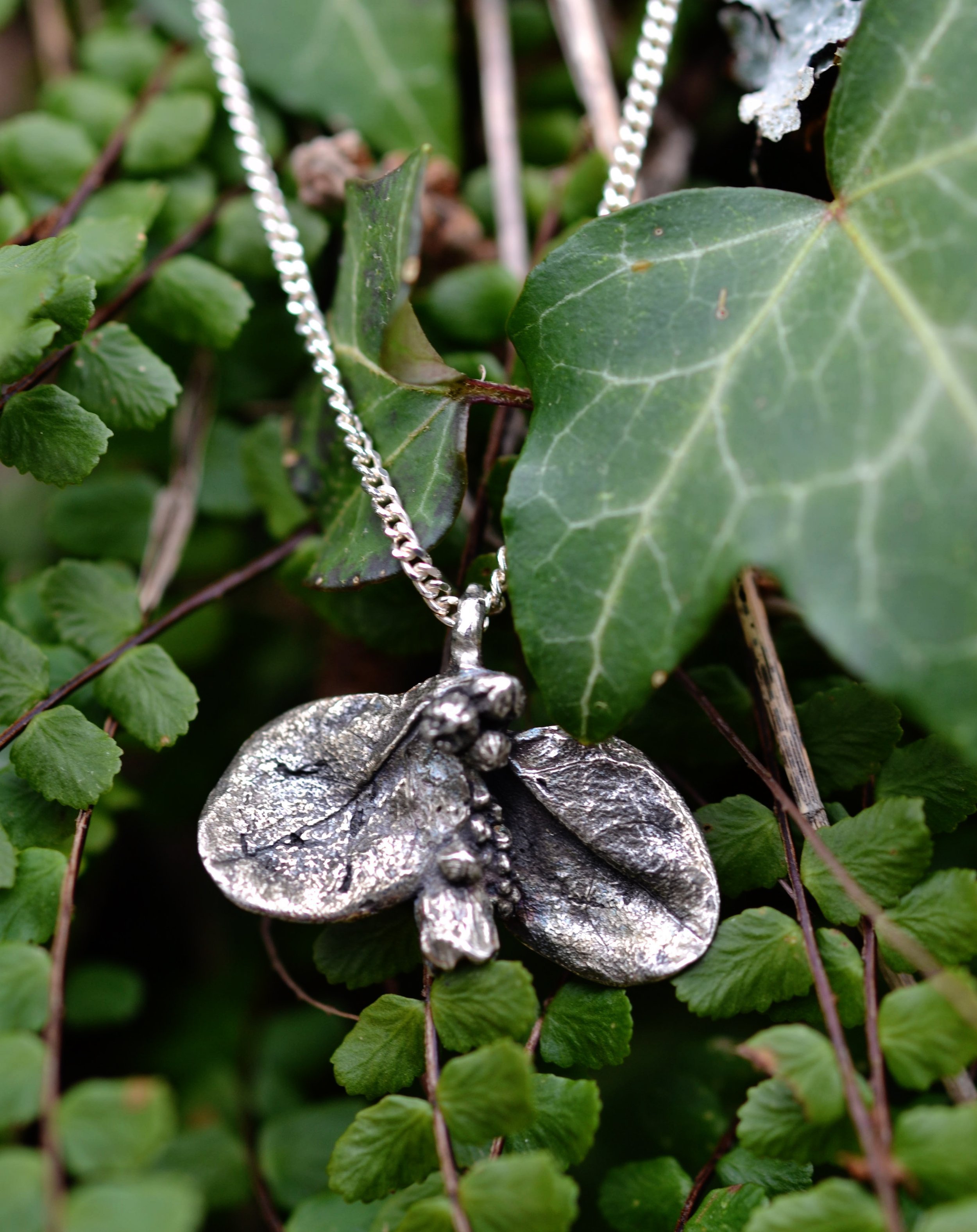 Pendentif feuille en argent massif posé dans la nature, par Bijoux de La Lande