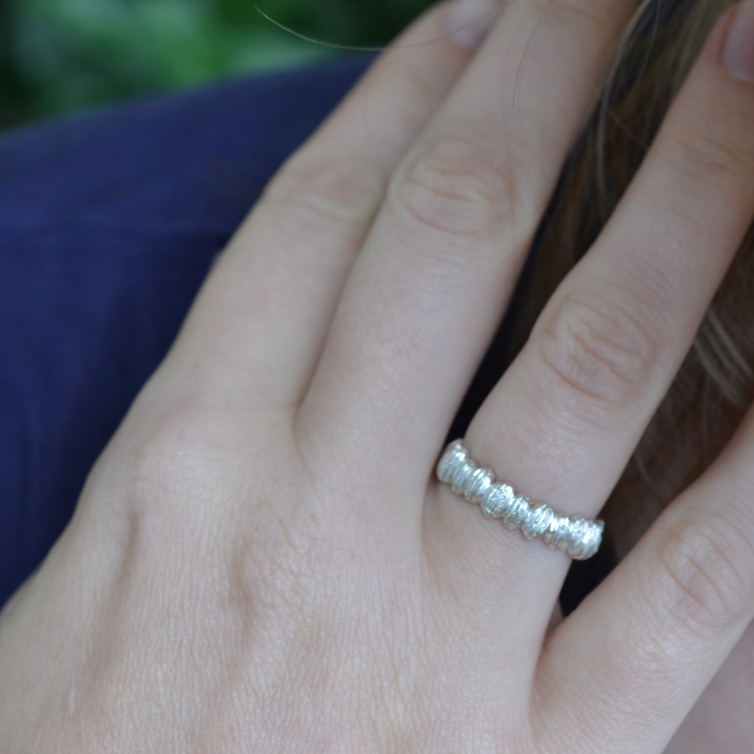 une main portant une bague avec de graines, par Bijoux de La Lande