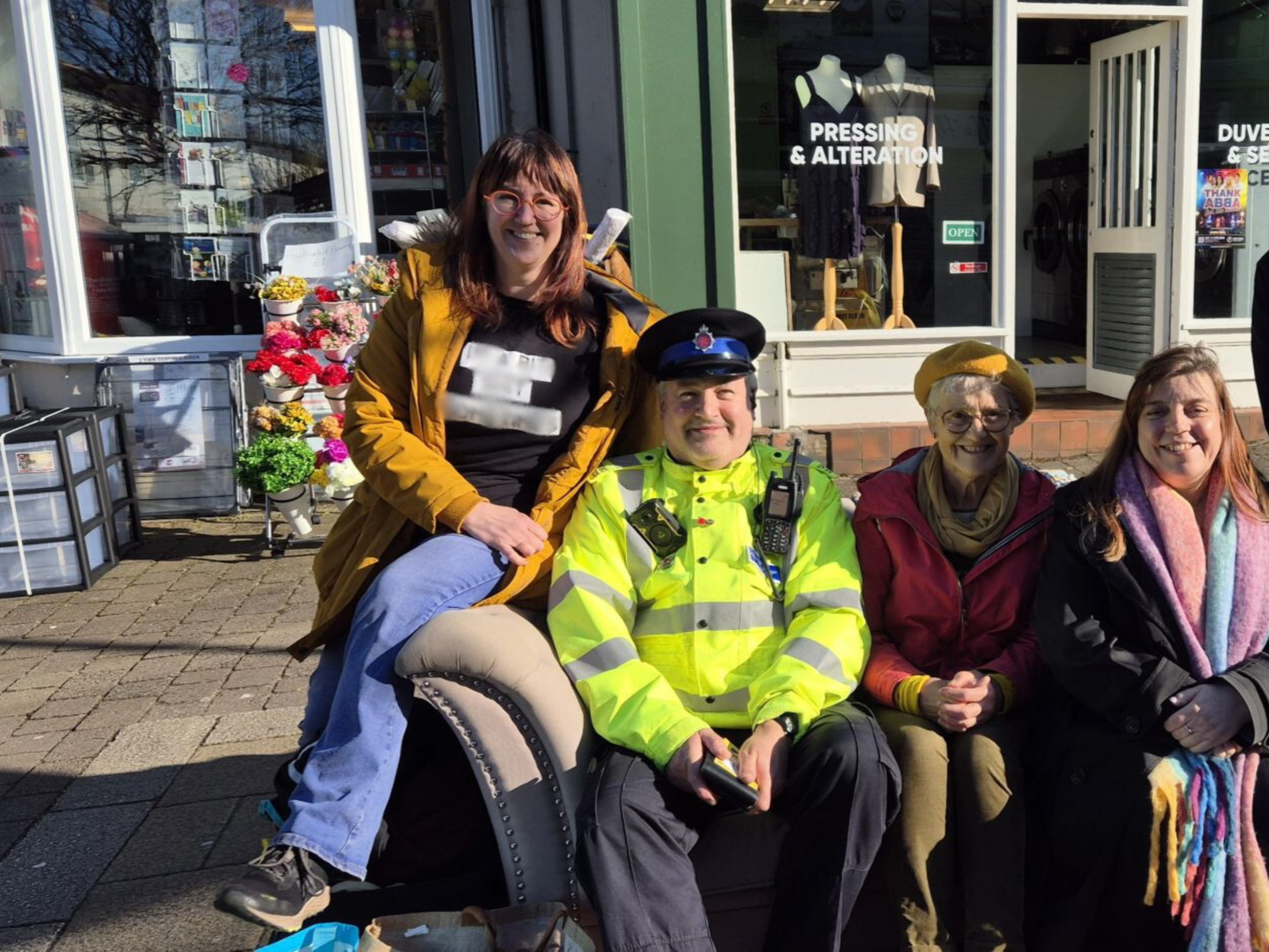 Residents sitting on a bench together at the Marple Living Room pop-up