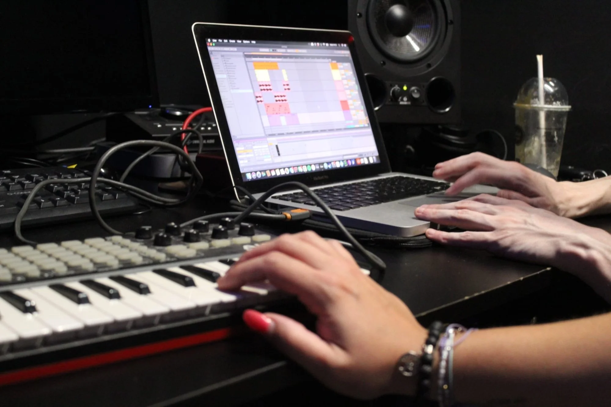 Photo shows a laptop and various musical equipment on a desk.