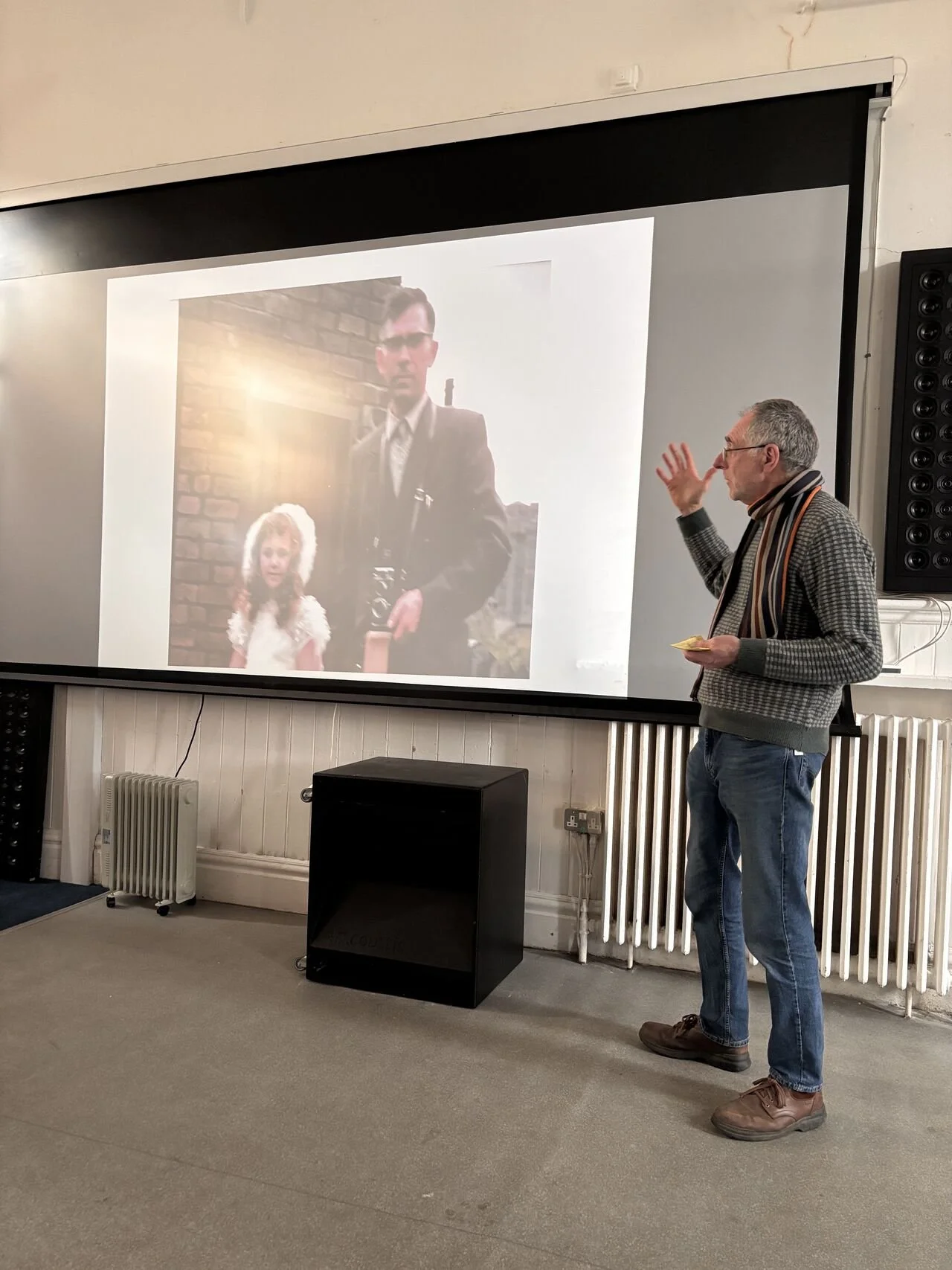 Image shows a ban standing aside a projection screen