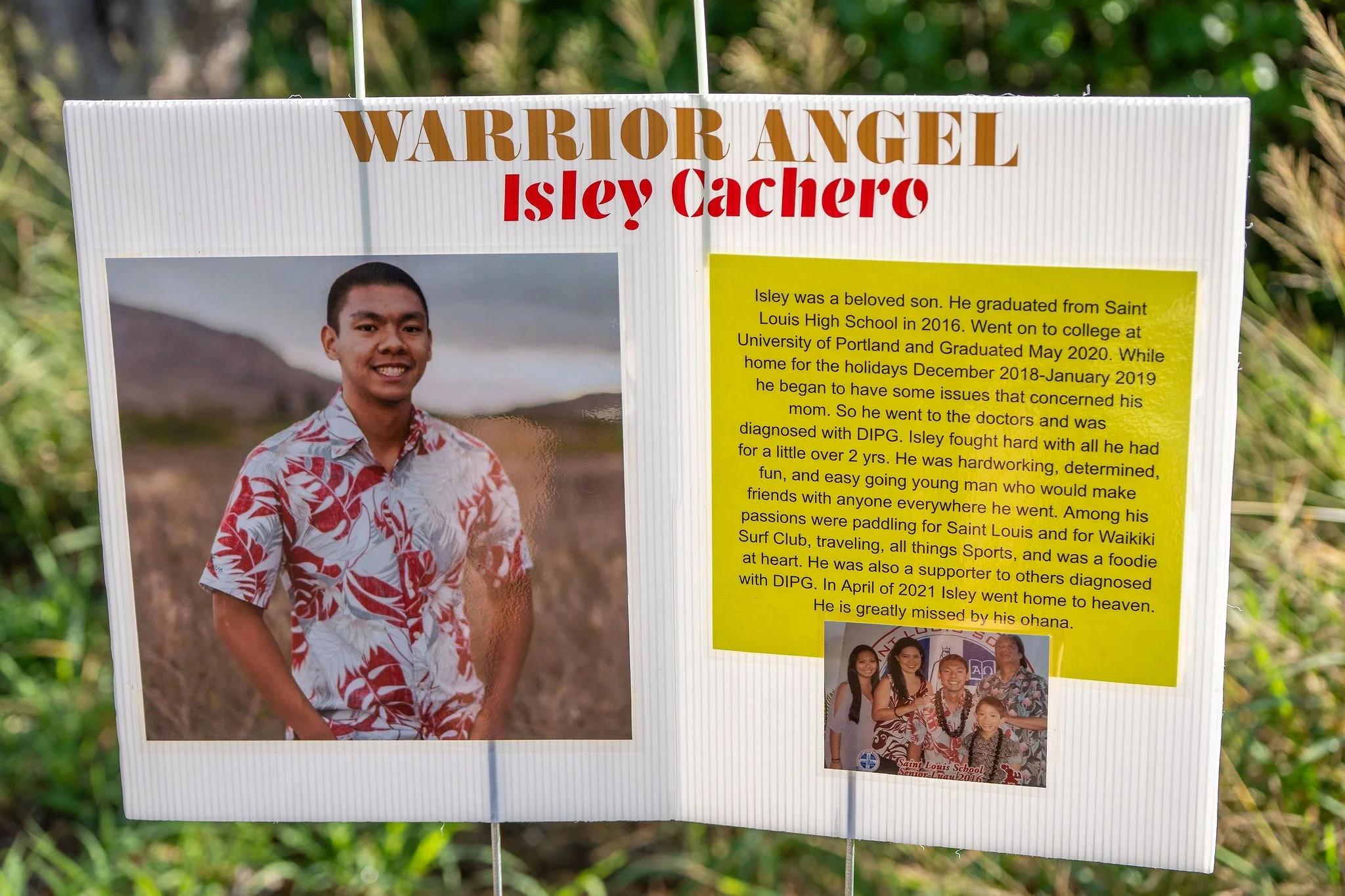 A memorial display for Isley Cachero, with a large photo of a young man in a tropical shirt, and a yellow paragraph describing his life and passing. Includes a smaller photo of him with family and friends.