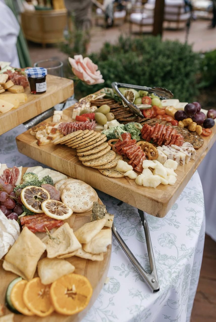 Artful grazing table with cheese, fruit, and charcuterie—styled for an elegant outdoor wedding reception