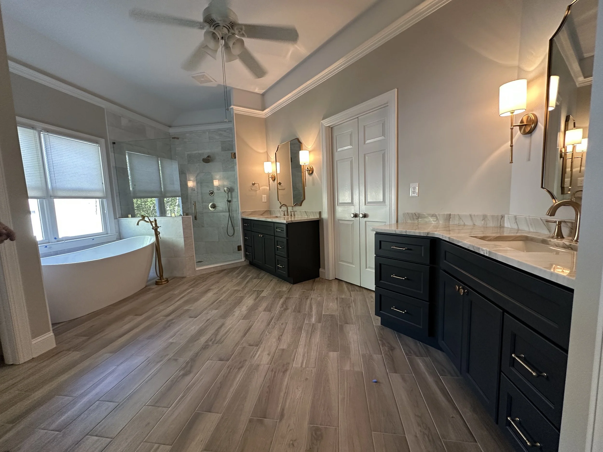 Completed primary bathroom renovation with freestanding tub and glass shower
