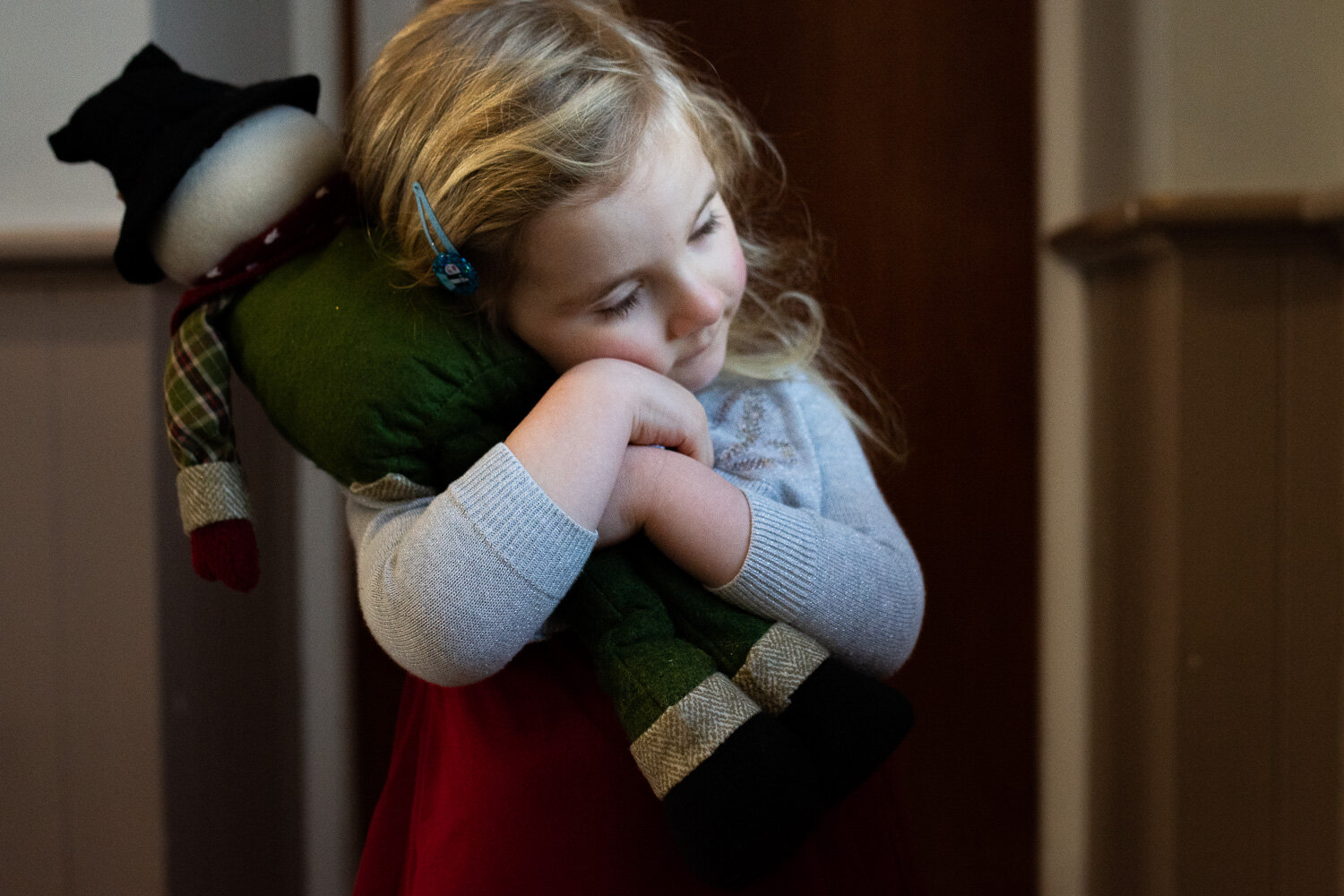 toddler girl hugging stuffed snowman