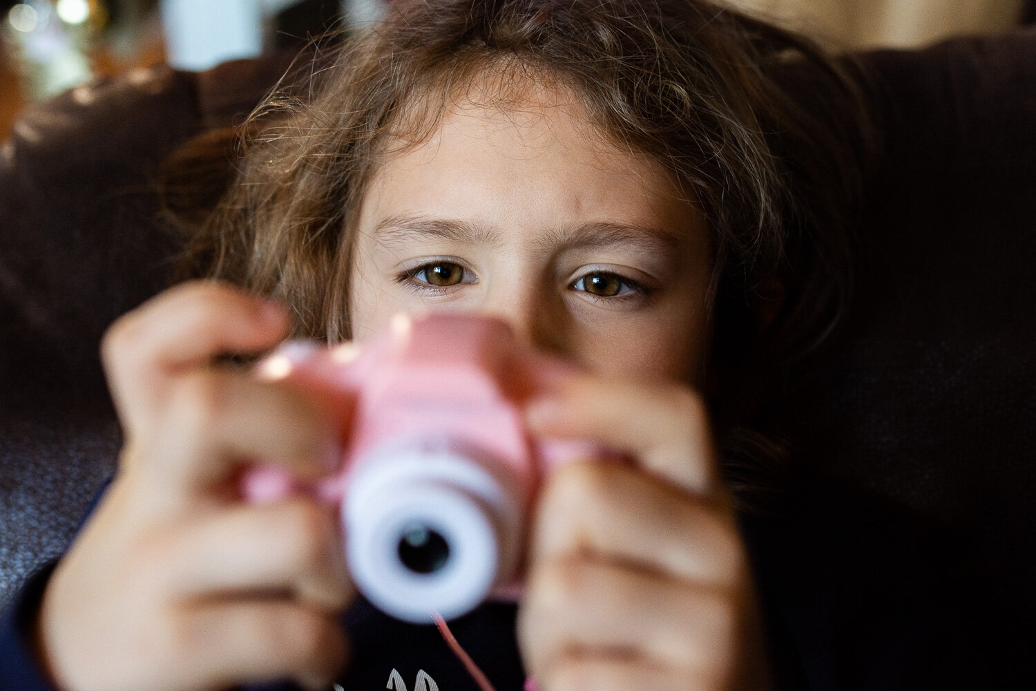 girl holding pink toy camera