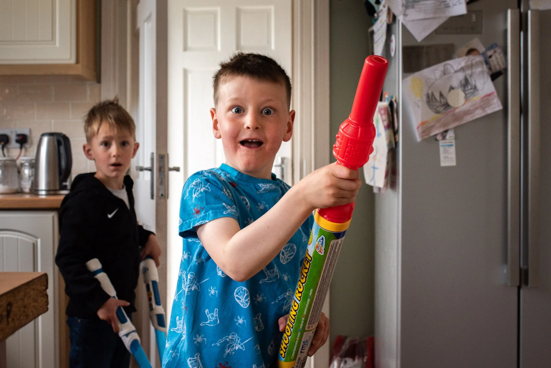 Boy with light saber grinning during party