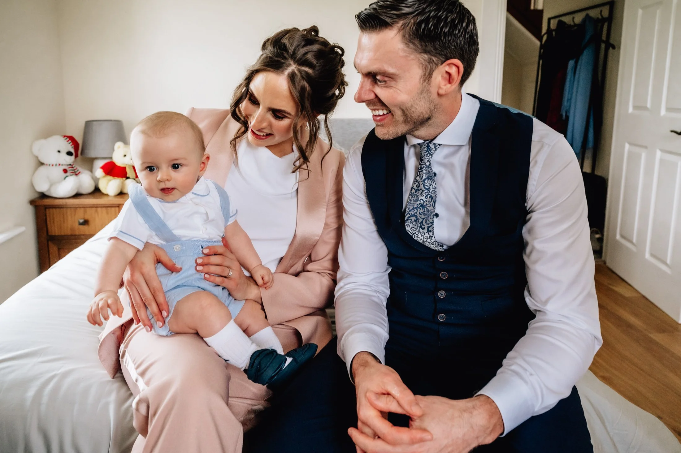 family sitting on edge of bed christening photos limerick photographer
