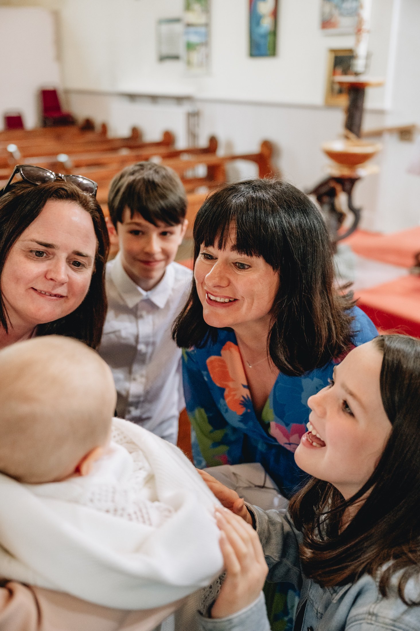 women around baby boy in church christening photos limerick photographer