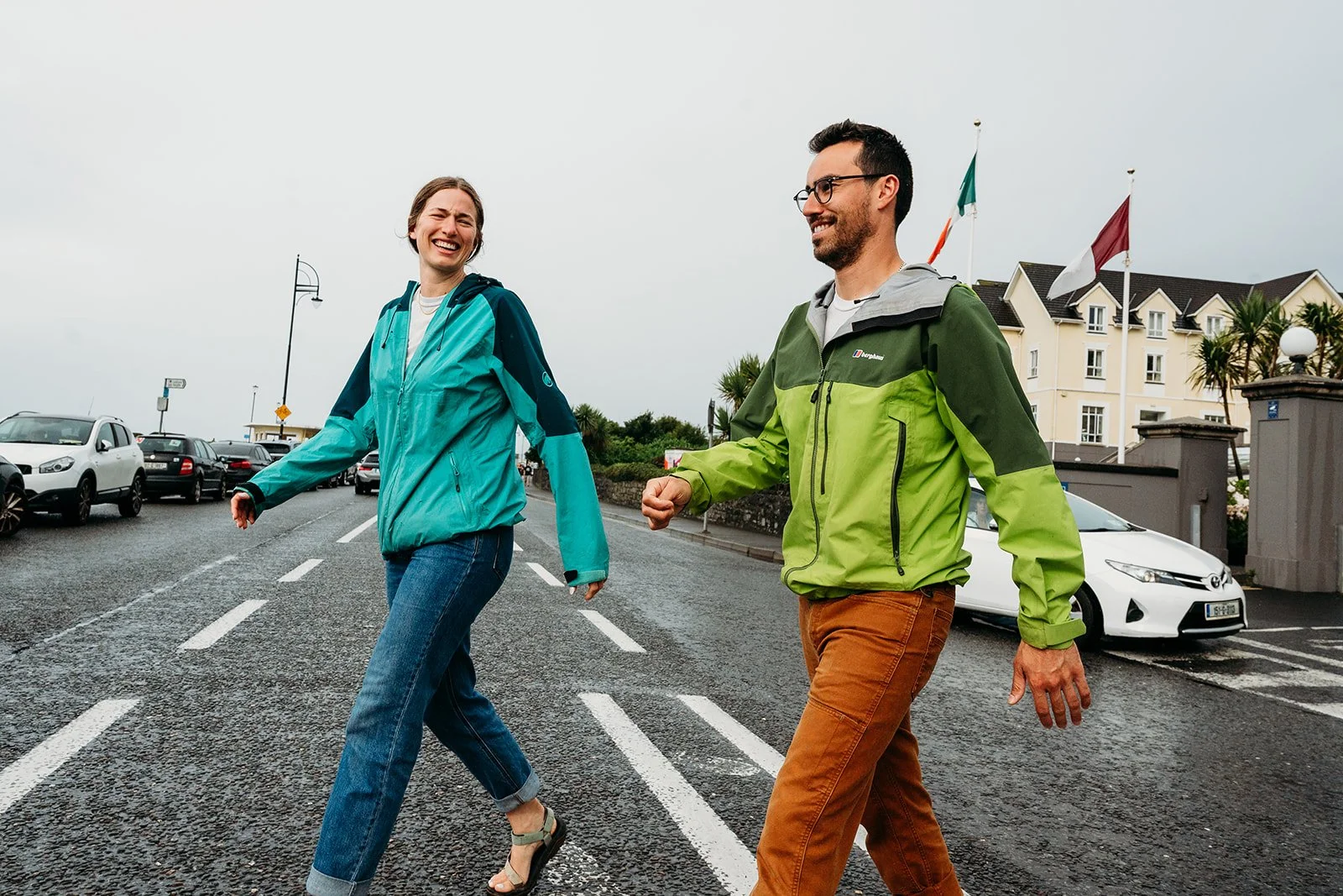 Galway Bay Hotel wedding photos woman and man in colourful windbreakers crossing the street