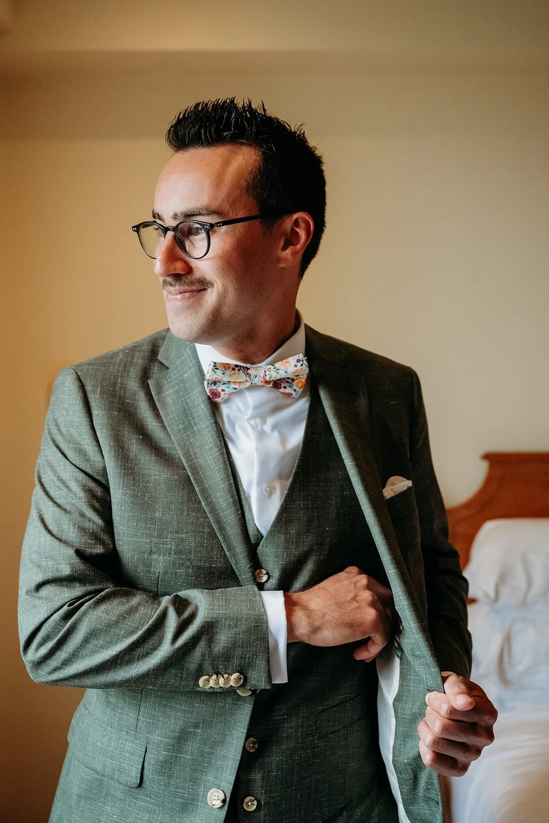Galway Bay Hotel wedding photos man in green wedding suit putting something in his pocket inside hotel room