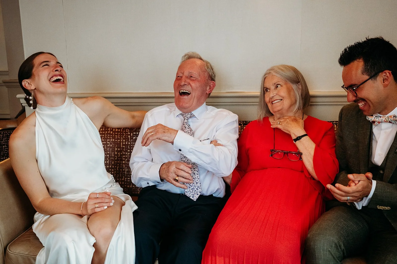 Galway Bay Hotel wedding photos bride and groom laughing with grandparents sitting on couch