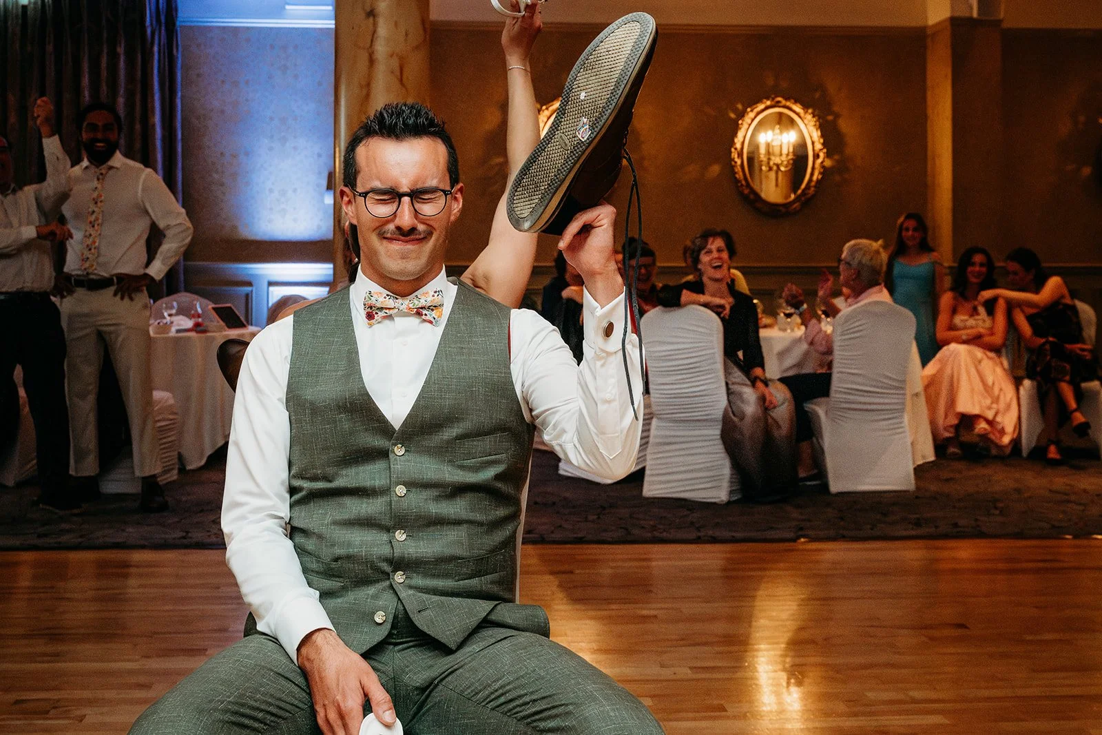 Galway Bay Hotel wedding photos silly face groom holding shoe during shoe gam