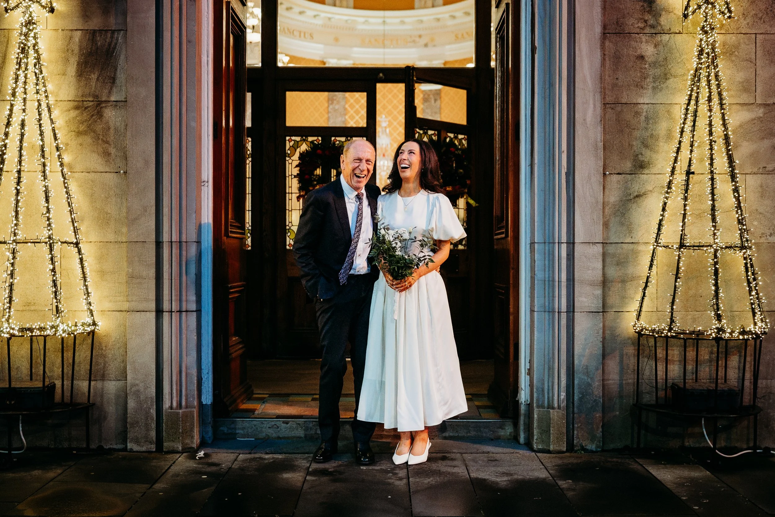 Wedding photo St Joseph's church Limerick city bride and father at church doors Christmas tree lights