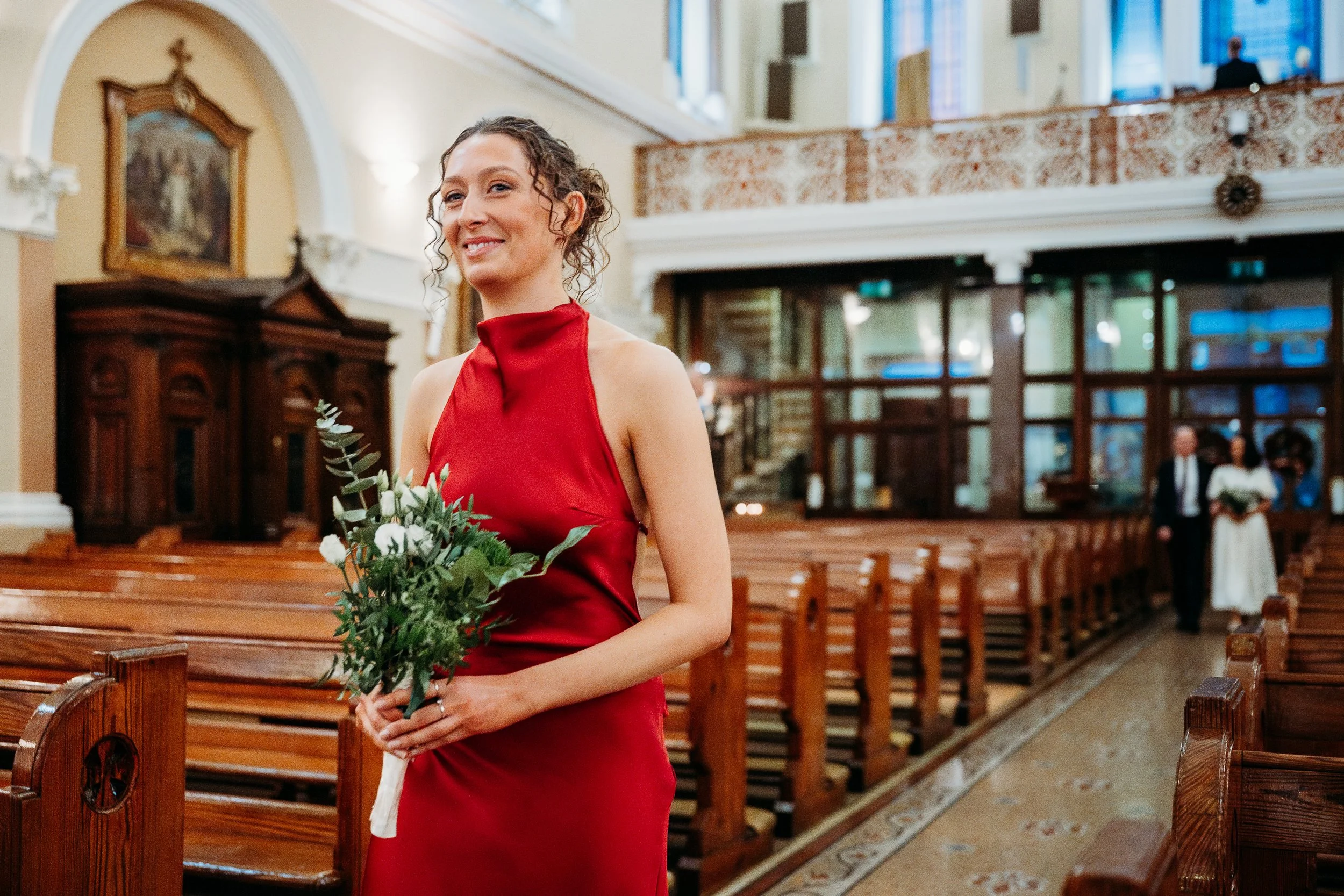 Wedding photo St Joseph's church Limerick city bridesmaid red dress walking down aisle