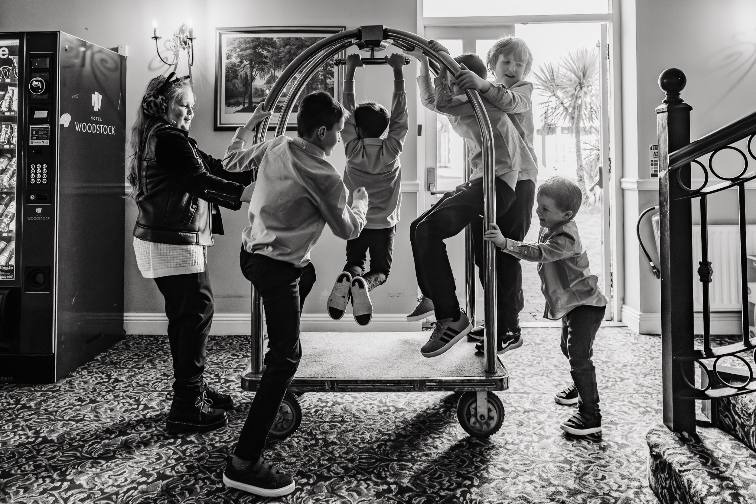 boys playing on luggage cart during Hotel Woodstock wedding photos candid natural photographer