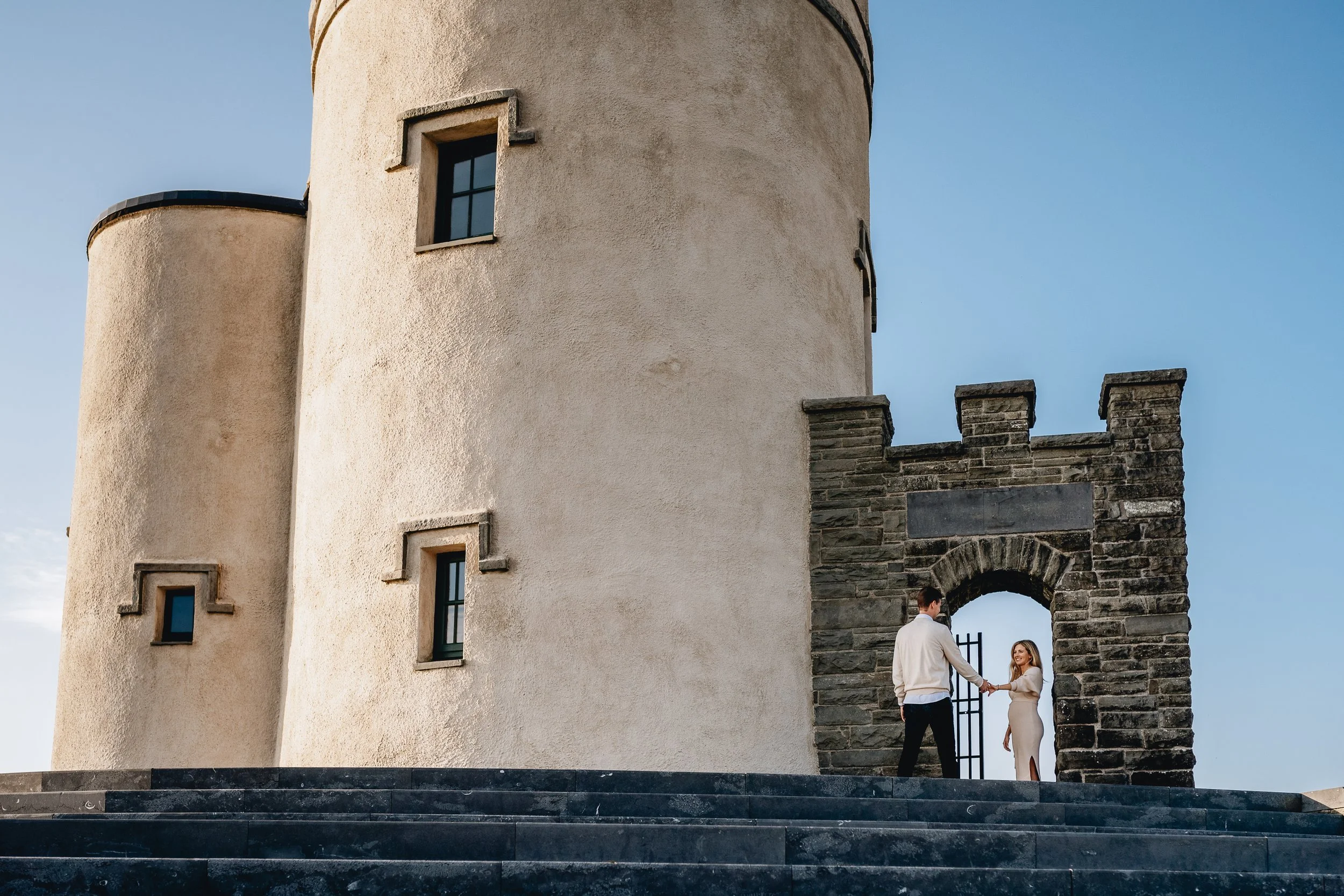 O'Brien's Tower Cliffs of Moher Maternity portrait with couple standing in arch of gate maternity photographer Ireland