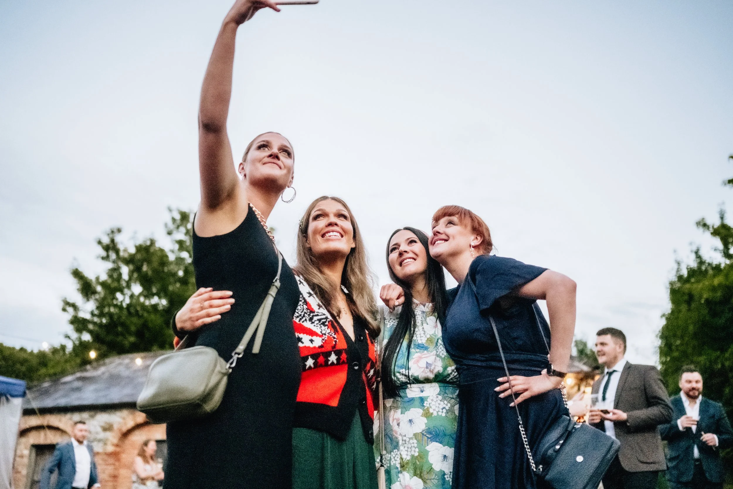 guests at a wedding take selfies 