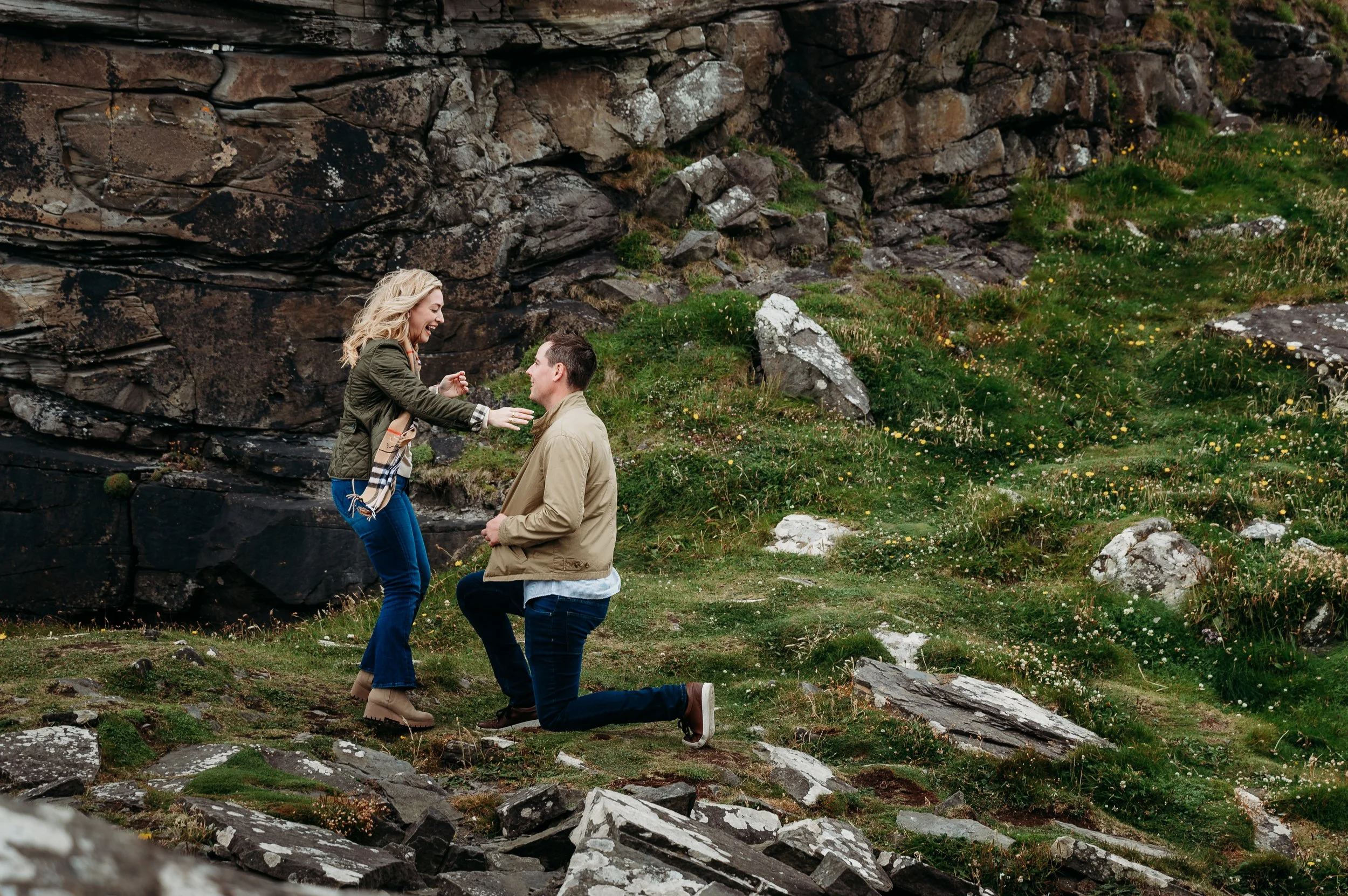 laughing girl proposal green grass dark cliffs ireland couples photographer Marie O'Mahony