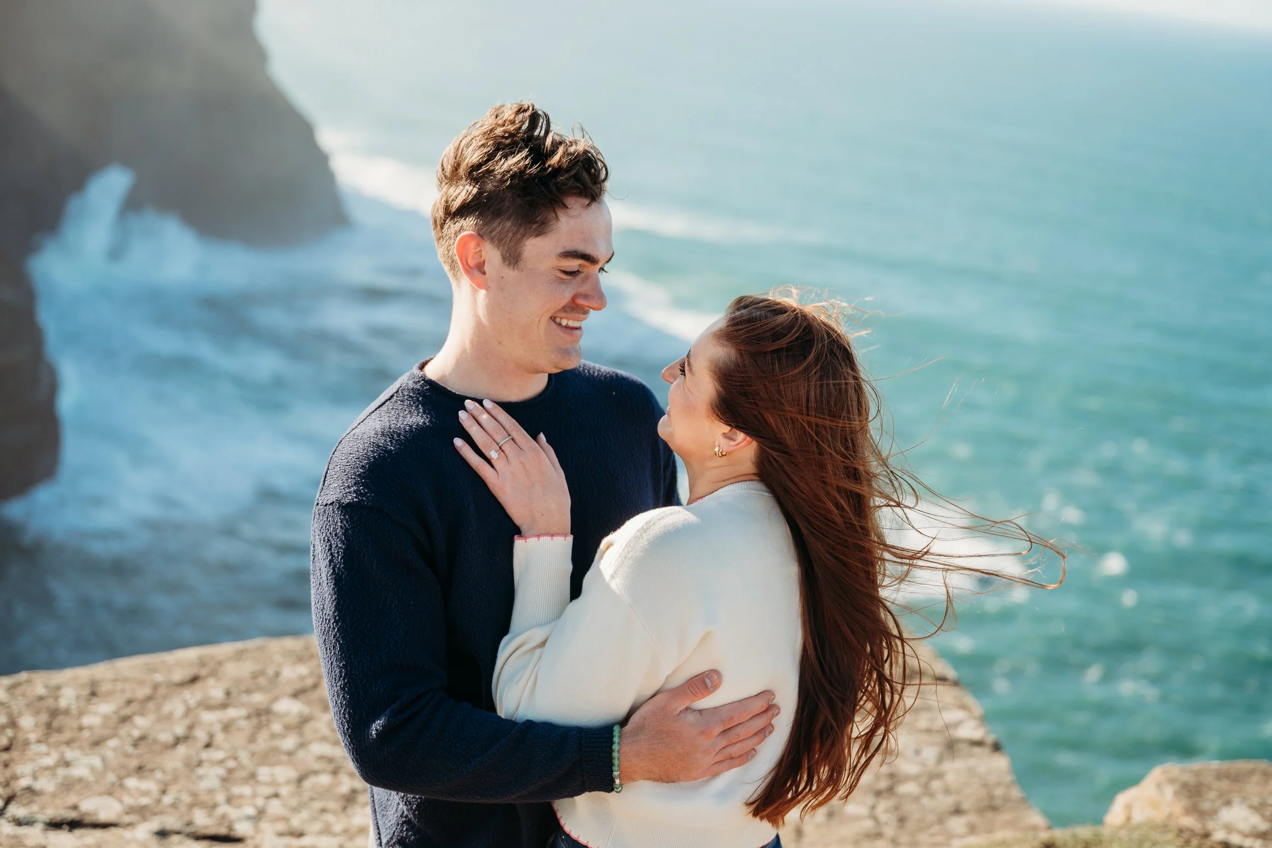 couple gazing at each other after getting engaged Cliffs of Moher Hags Liscannor proposal photographer Ireland Co Clare