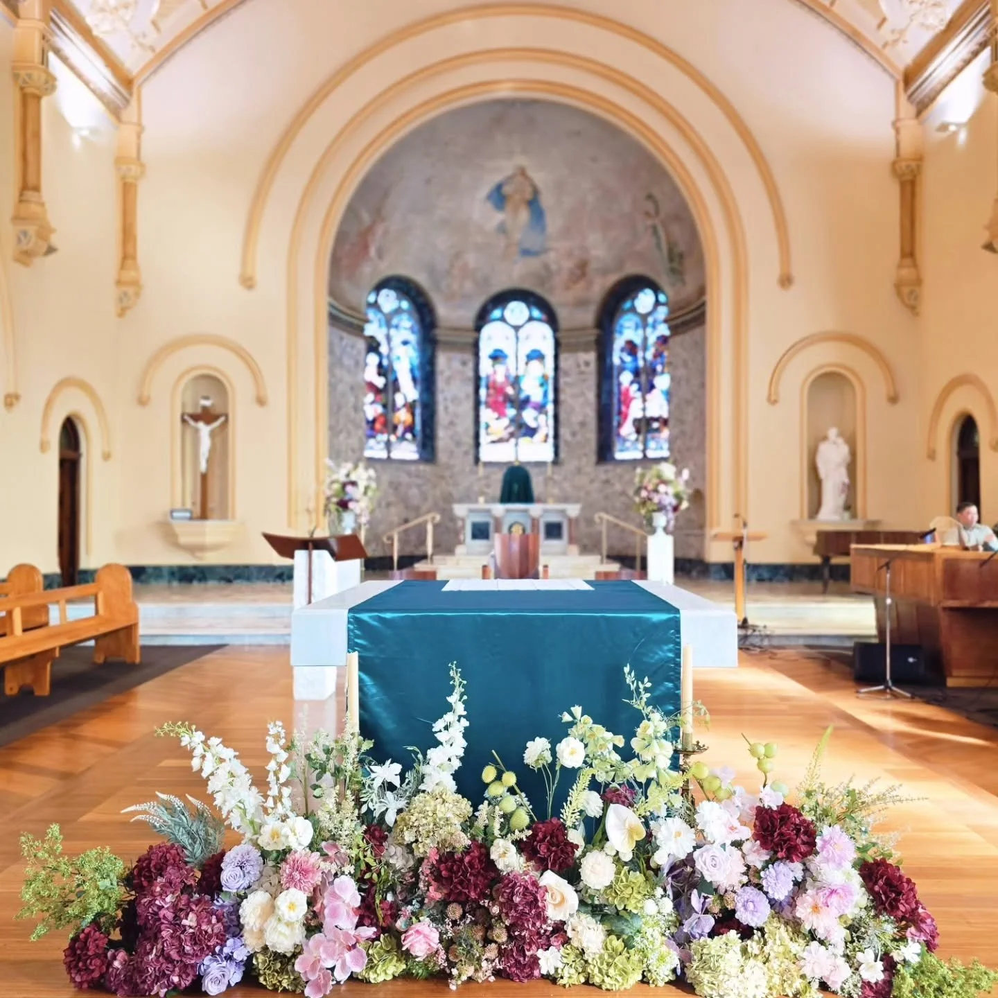 Blush pinks, soft lilacs, rich burgundy tones, and layered greenery, creating an elegant, garden-inspired arrangement with plenty of depth and texture.

Our Lady of Mt. Carmel Catholic Church