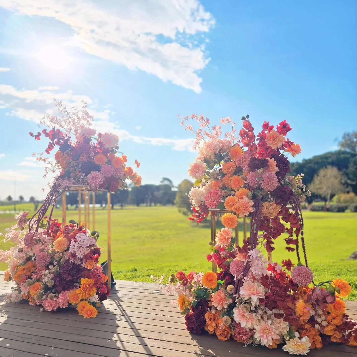 A burst of colour under the open sky 🌸☀️
@greenfieldsalbertpark

Layers of warm peach, blush, burgundy and vibrant orange come together in this lush garden-inspired ceremony setting. We love how the florals glow in the afternoon sunshine against all