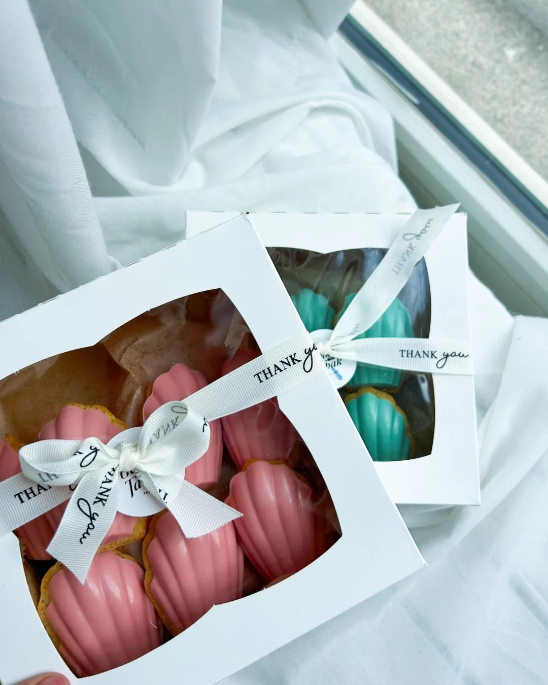 Two boxes of baby shower madeleines &mdash; half in blush pink, half in baby blue. 

Because nothing says &lsquo;sweet arrival&rsquo; quite like chocolate-dipped bites that are almost too cute to eat&hellip; almost! 

Lets celebrate! Ask about the &q