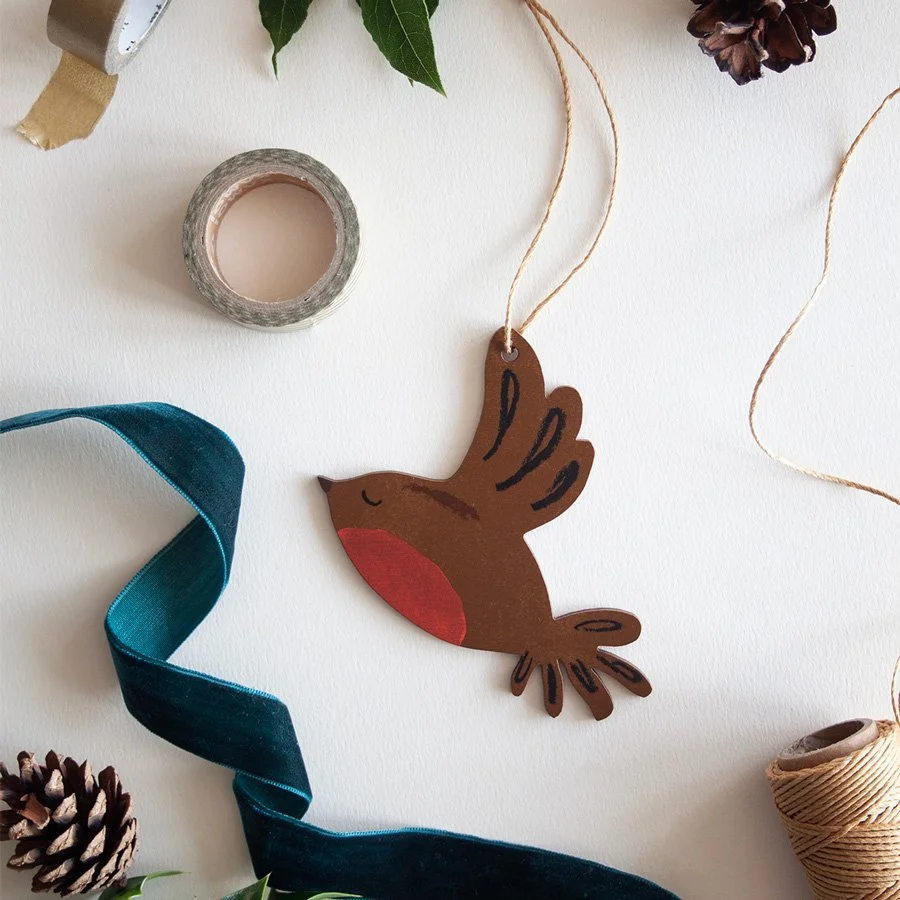 Robin Christmas decoartion on plain background styled with ribbons and pine cones