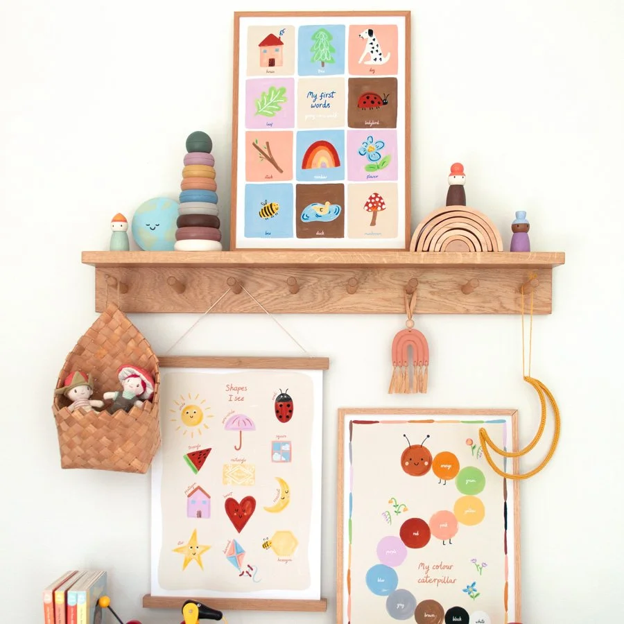 Colours nursery print styled with first words nursery print and shapes nursery print on wooden peg shelf with rainbow nursery decor