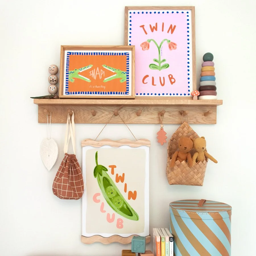 Twin Nursery Prints styled on a picture shelf