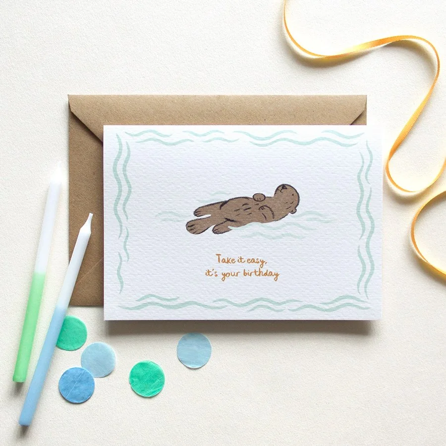 Otter Birthday Card styled with birthday candles, confetti and ribbon