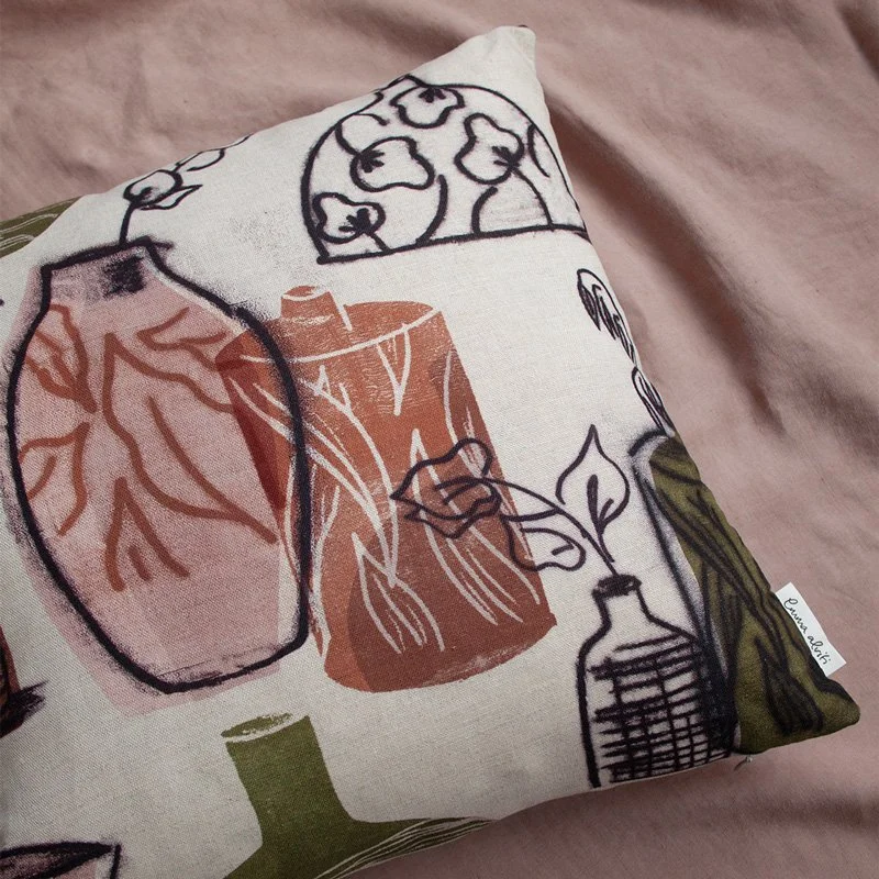 Still Life Vase Pink / Terracotta / Olive Green Fabric as a cushion styled on pink linen