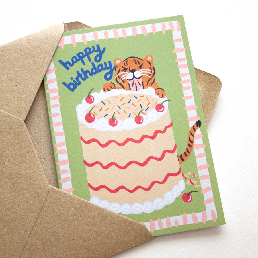 Hungry Tiger Birthday Card eating giant birthday cake pictured on angle in kraft envelope