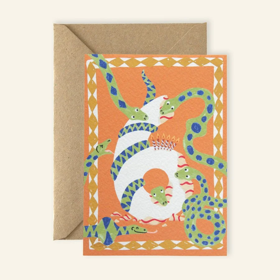 Snakes 6th Birthday Card with kraft envelope on plain background