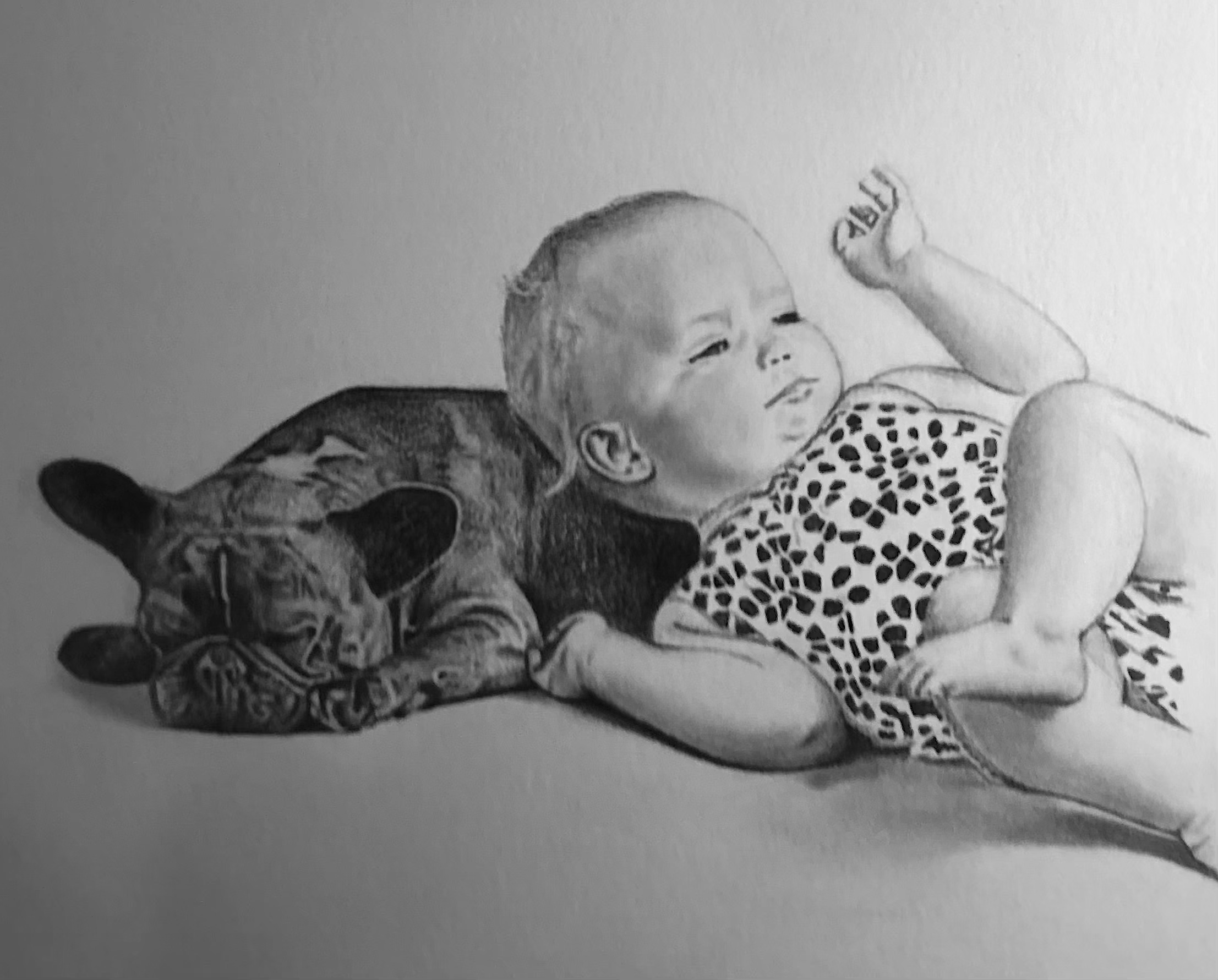 A young child lying on a stuffed animal, possibly a tiger, with one arm raised and making a fist, wearing a patterned shirt.